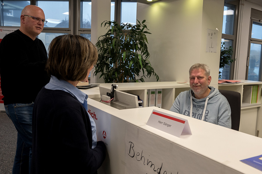 Sachbearbeiter Sänger erläutertAnpassungen an seinem Arbeitsplatz