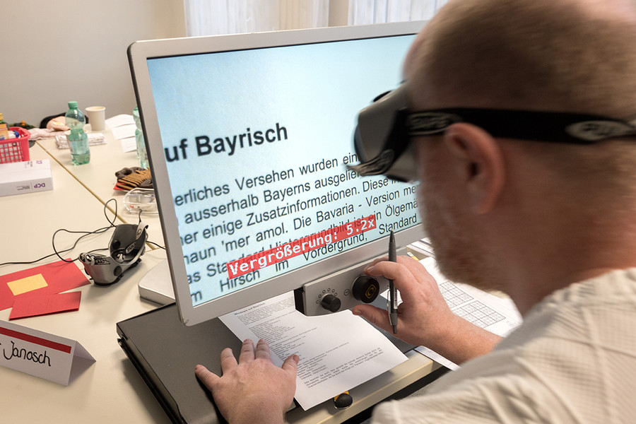 Am Stand des LWL Berufsbildungswerkes wird die Funktion eines Lesegerätes gezeigt.