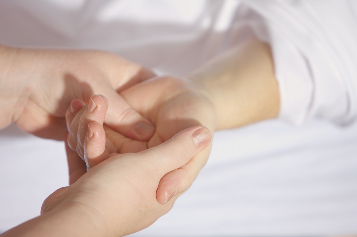 Eine Pflegeperson hält die Hand einer pflegebedürftigen Person. 