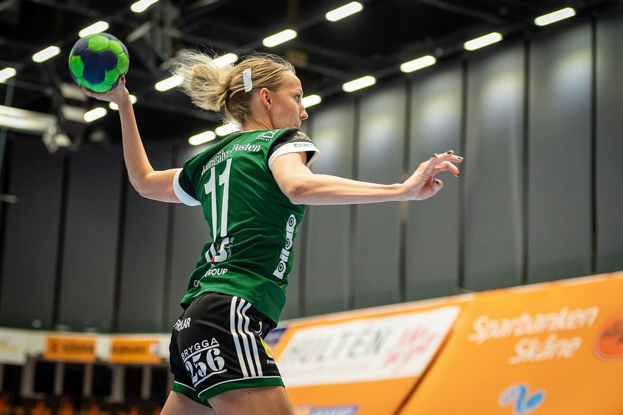Das Foto zeigt eine Frau die Handball spielt. Sie wirft einen Ball