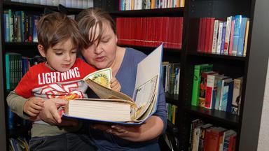 Mutter liest ihrem Kind aus einem Buch vor. Foto: Tobias Franke