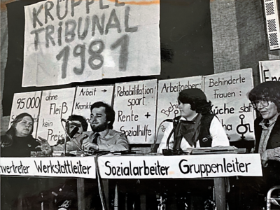 Das Foto zeigt das Podium des Krüppeltribunals. Es fand am 13. Dezember 1981 in Dortmund statt.
