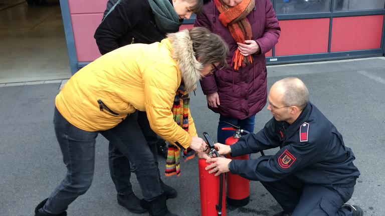 Auf dem Foto erklärt Hauptbrandmeister Bernd Rogge, wie man einen Feuerlöscher entsichert.
