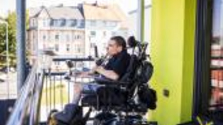 Das Foto zeigt einen Mann im Rollstuhl auf dem Balkon seiner Wohnung. Forscher haben ermittelt, dass Menschen mit Behinderung bis ins hohe Alter möglichst lange in der eigenen Wohnung leben möchten. Foto: LWL