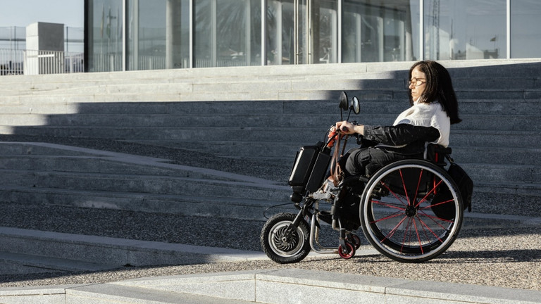 Frau im Rollstuhl auf der Straße