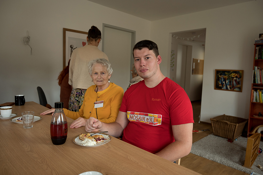 Erika und Roman sitzen nebeneinander am Tisch