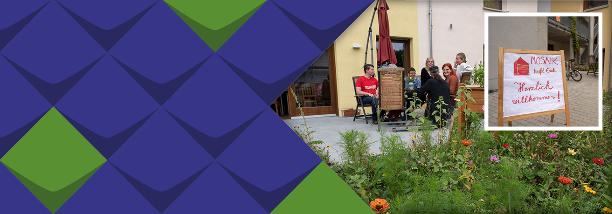 Willkommen bei MOSAIK steht auf einem Schild, auf einer Terrasse sitzen einige Wohnprojektbewohnerinnen