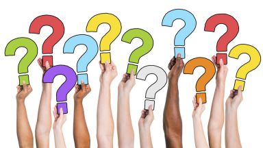 Viele Fragezeichen an den Händen verschiedener Menschen 