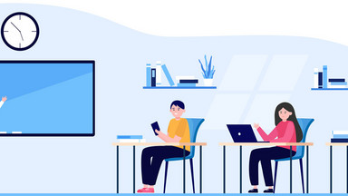 Schulung im Klassenzimmer. Eine Lehrerin unterrichtet an der Tafel und vorne sitzen drei Schüler*innen mit Laptops auf den Tischen. 