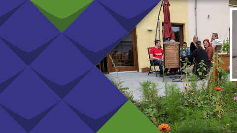 Willkommen bei MOSAIK steht auf einem Schild, auf einer Terrasse sitzen einige Wohnprojektbewohnerinnen