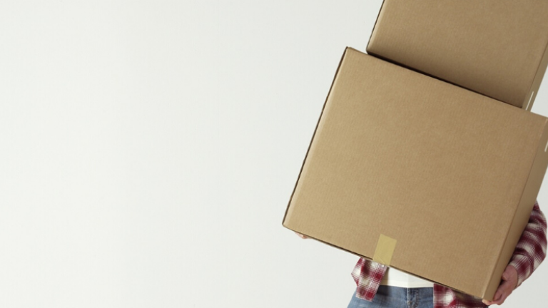 Eine Person trägt Umzugskartons.