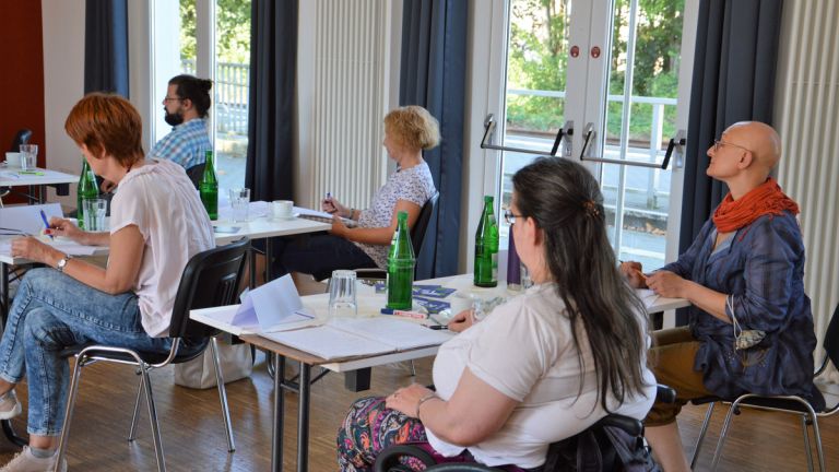 Die Teilnehmer*innen hören dem Vortrag von Claudia Middendorf konzentiert zu.