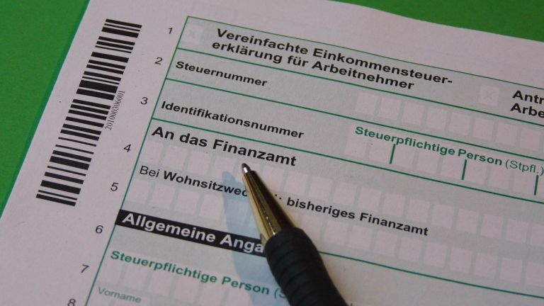 Das Bild zeigt das Formular für die Einkommenssteuererklärung und einen Stift.