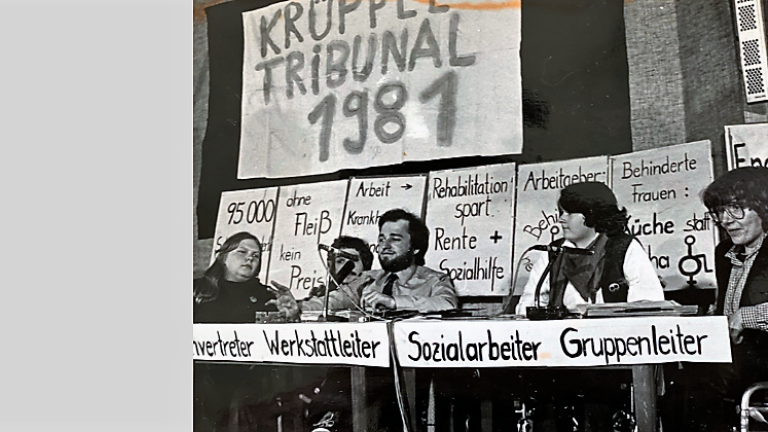 Das Foto zeigt das Podium des Krüppeltribunals. Es fand am 13. Dezember 1981 in Dortmund statt.