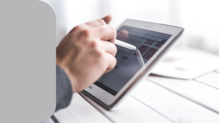 Eine Hand, die mit einem Stift auf einem Tablet entlangfährt.