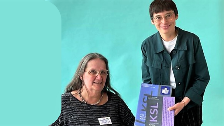 Das Foto zeigt links Christiane Rischer vom KSL Arnsberg und rechts daneben Ministerin Josefine Paul. Die Ministerin hält den Ratgeber für Eltern mit Behinderung in Händen.