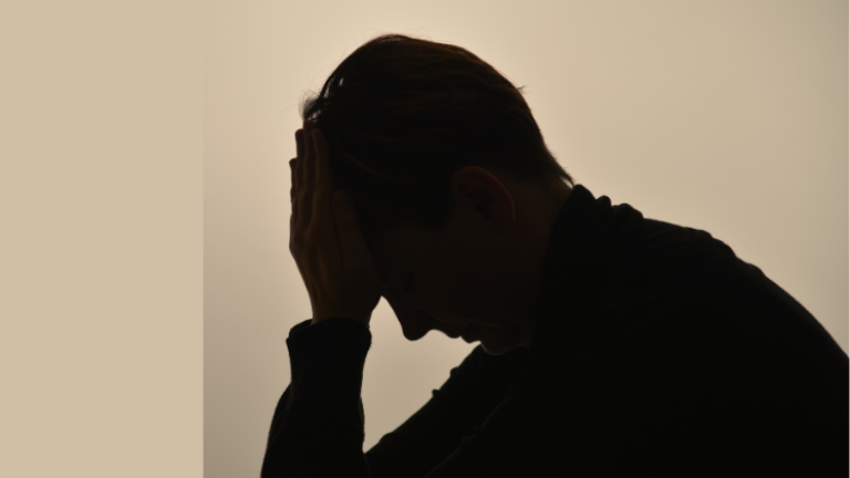 Eine Person stützt ihren Kopf auf einer Hand.