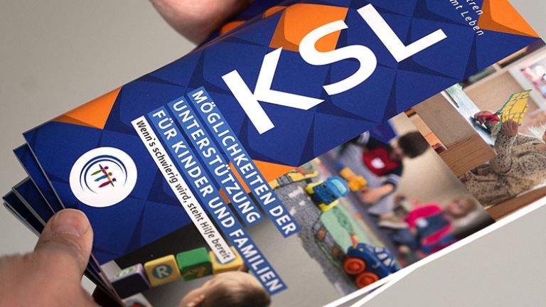 Eine Hand hält den beschriebenen Flyer