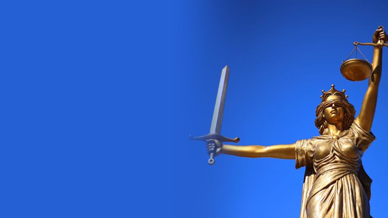 Goldfarbene Statue der Justitia mit Augenbinde und Waage